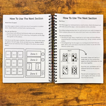 Open spiral-bound book with gardening planning pages on a wooden surface