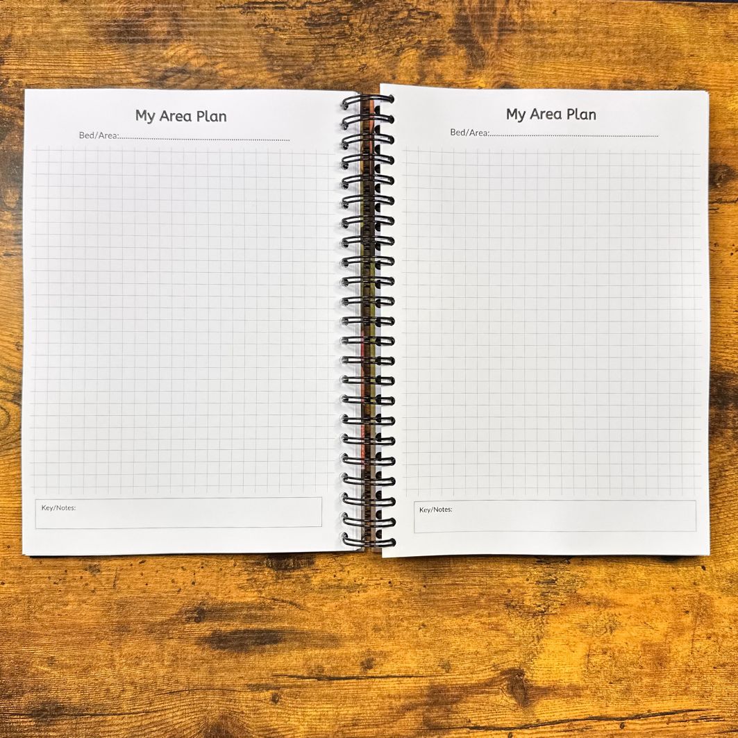 Open spiral-bound notebook with grid pages on a wooden surface
