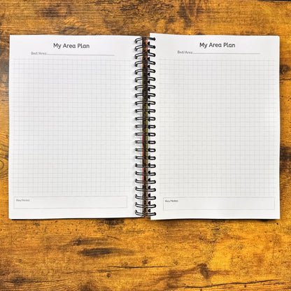Open spiral-bound notebook with grid pages on a wooden surface